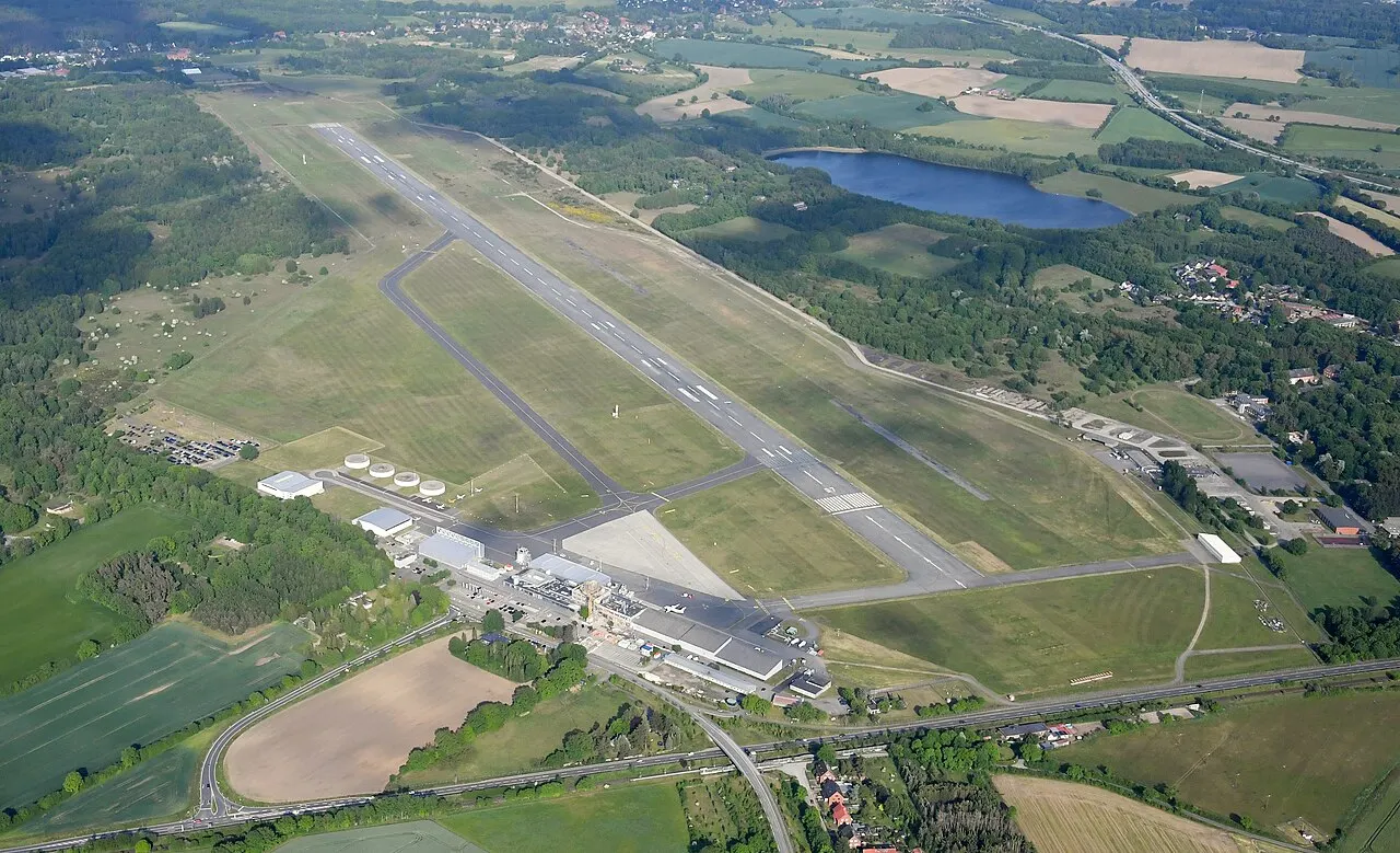 Widok z lotu ptaka na pas startowy i terminal otoczone lasami i jeziorami