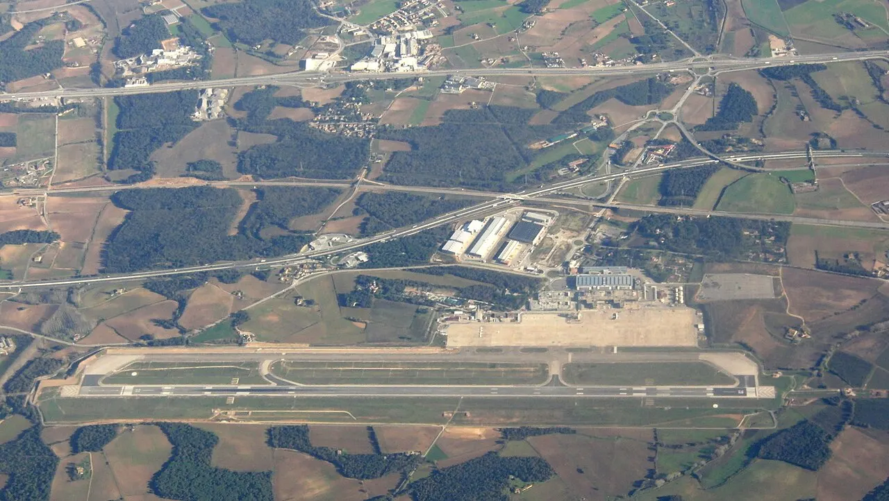 The airport and its runway from the air, among fields and woods