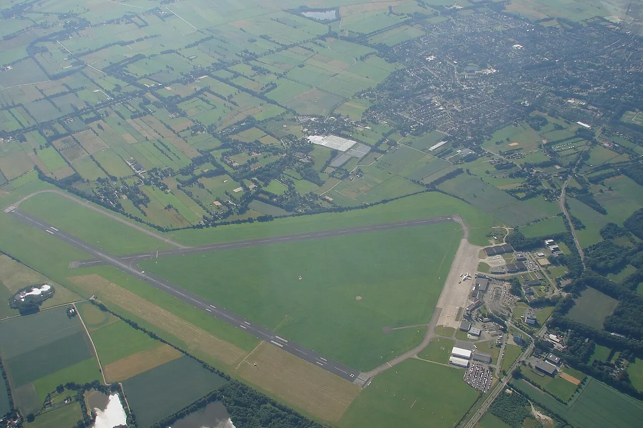 Vista aérea da pista e dos terrenos do aeroporto, numa paisagem plana