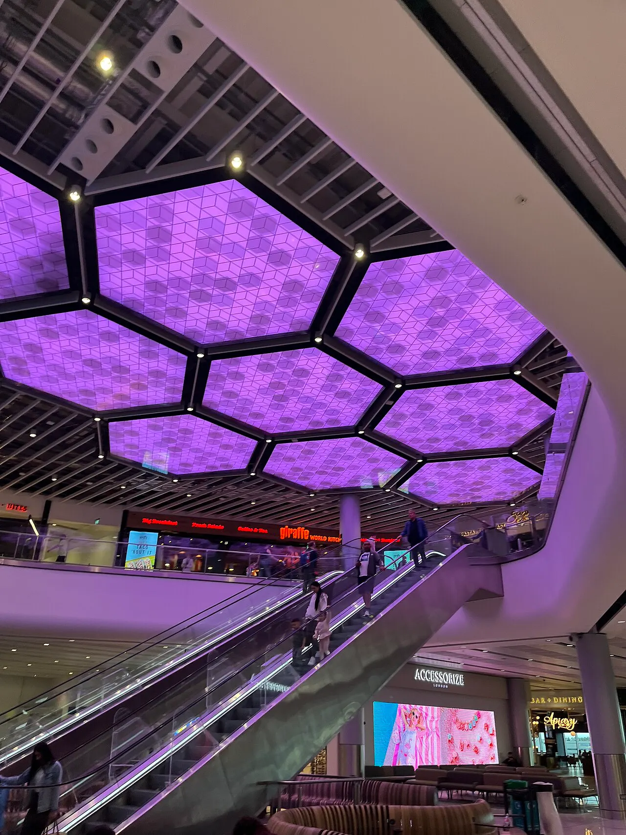Im Terminal 2, mit Rolltreppen und beleuchteter Decke