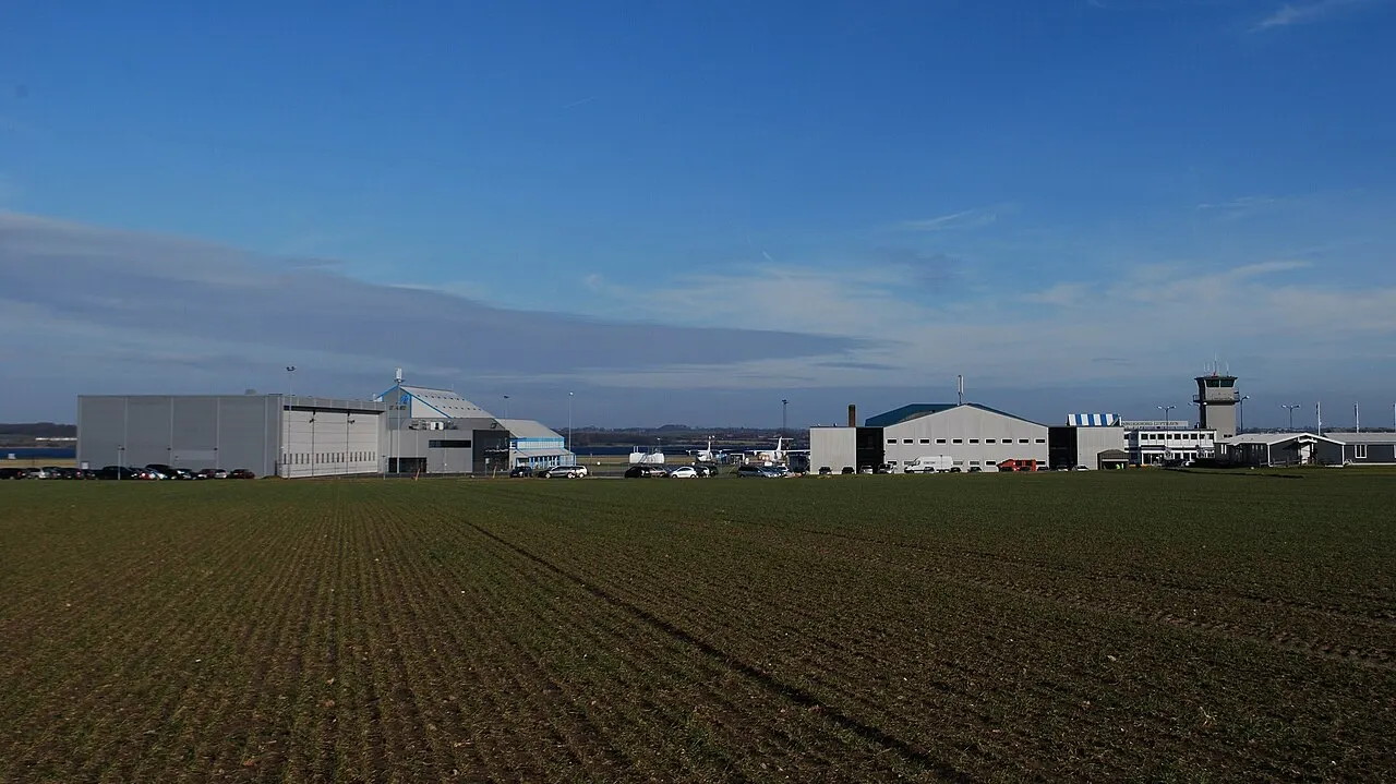 Der Flughafen von den Feldern aus gesehen, mit Hangars und Turm