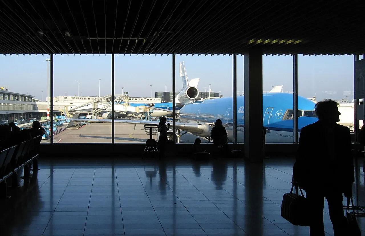 Vista desde el interior de la terminal hacia un avión en la puerta de embarque