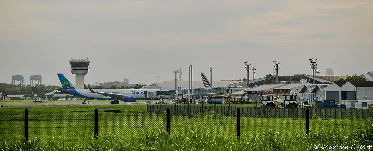 Een vliegtuig bij de terminal, met de verkeerstoren
