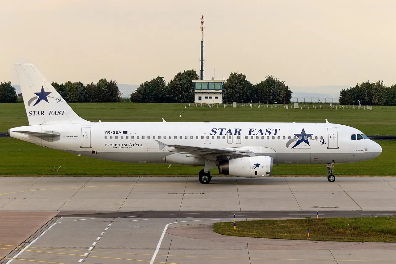 Un Airbus A320 rueda hacia la terminal, con la torre de control al fondo