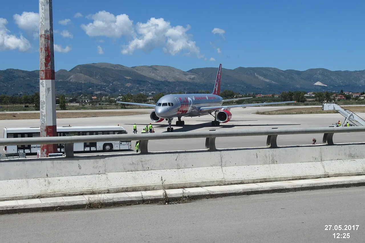 An aircraft on the apron, with the island's hills behind